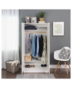 a white closet with clothes and shoes on the shelves next to a chair in front of a window