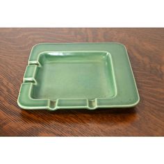 an empty green tray sitting on top of a wooden table