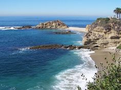 the beach is next to some rocks and water