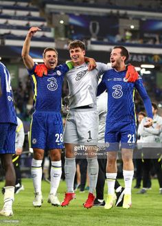 soccer players celebrating on the field with their arms in the air and one man holding his head