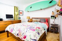 a bedroom with a surfboard hanging above the bed