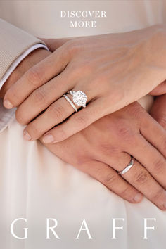 the bride and groom are holding each other's hands with their wedding rings on their fingers