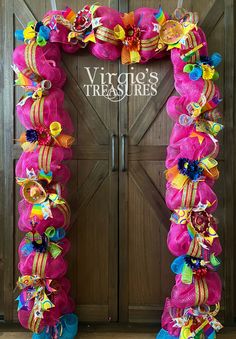 a pink door decorated with colorful ribbons and bows