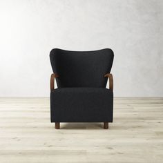 a black chair sitting on top of a hard wood floor next to a white wall