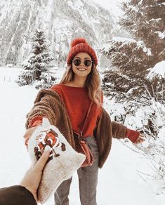 the instagram photo is being taken on her phone, and it looks like she's having fun in the snow