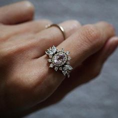 a woman's hand with a ring on it and an engagement ring in the middle