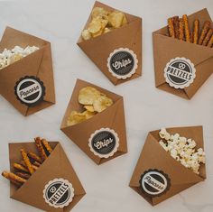 six brown envelopes filled with snacks on top of a table