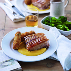 a white plate topped with meat next to broccoli and other foods on a table