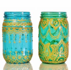 two blue jars with gold designs on them sitting next to each other in front of a white background