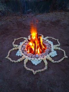 a fire pit with rocks and stones around it in the shape of a flower arrangement