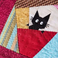 a close up of a quilt with a cat on it