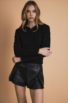 Elevate your sweater game with our Leather Cable Knit Sweater. This stylish piece boasts a classic knit pattern that adds texture and dimension to your look. The faux leather collar and placket add a touch of edginess, while the V neckline and long sleeves create a flattering silhouette. Crafted from a soft and cozy fabric, our sweater will keep you warm and comfortable all day long. Effortlessly chic, this sweater is a must-have for any fashion-forward individual. Faux Leather Shorts, Cozy Fabric, Edgy Look