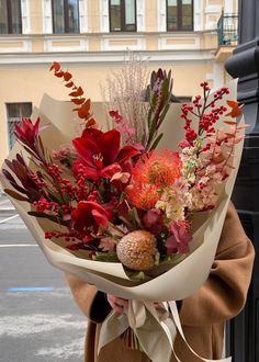 a woman holding a bouquet of flowers in her hands