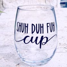 a wine glass with the words shut duh fuh cup on it sitting on a table