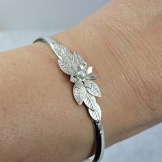 Adorn your wrist with a silver floral corsage in this wildflower sterling silver cuff bracelet. This elegant flower cuff bracelet is entirely hand-wrought from recycled sterling silver where detailed leaves surround a hand-sculpted white wildflower set with a cultured freshwater pearl in serrated bezel setting. Bracelet is hand-polished to a high shine and is available in sizes small, medium, and large, with a 1.25 inch opening at the back of cuff. If you are unsure of your wrist size, please vi Cabachon Jewelry, Floral Corsage, 14kt Gold Jewelry, Flower Cuff Bracelet, Flower Cuff, Metal Smithing, Bracelets Silver, Style Lookbook, Jewelry Bracelets Silver