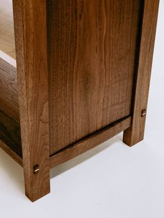 a close up of a wooden cabinet on a white surface with no one around it