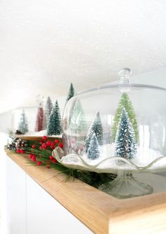 a glass bowl filled with christmas trees on top of a counter