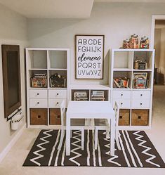 a white table sitting in front of a book shelf next to a blue and white rug