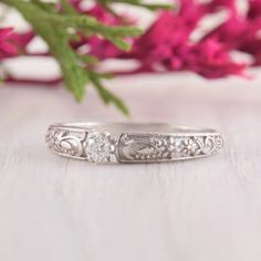 a close up of a wedding ring with flowers in the background