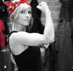 a woman flexing her muscles with a red bow on her head