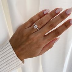 a woman's hand wearing a diamond ring