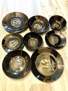 six black and gold plates with skulls on them