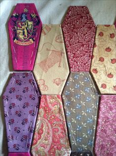 six different colored ties laid out on a white cloth covered table with the crest of hogwart's house