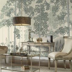 a living room with two chairs and a table in front of a tree wallpaper