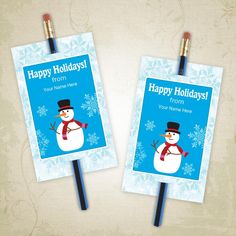 two snowmen with hats and scarfs on top of each other, one is holding a sign that says happy holidays