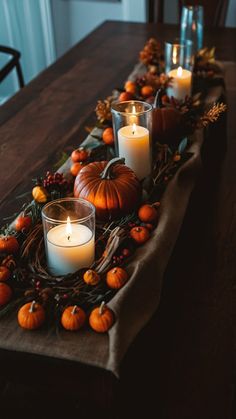 a table with candles and pumpkins on it