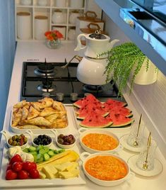 an assortment of fruits and vegetables on a tray in front of a stove top oven