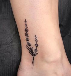 a small ankle tattoo with flowers on it