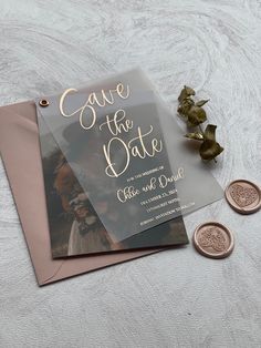 wedding save the date card with two coins next to it on top of a table