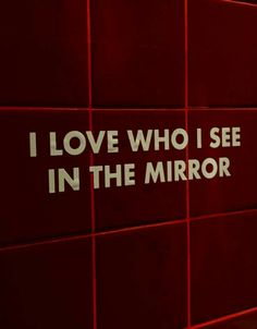 i love who i see in the mirror sign on a red wall with white lettering