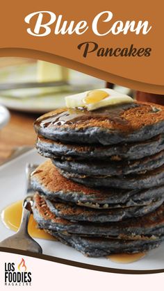 blue corn pancakes with butter and syrup on a white plate, ready to be eaten