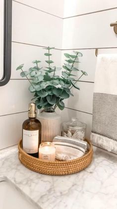 a bathroom counter with soap, lotion and plants on it