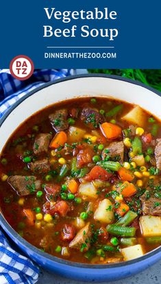 a bowl filled with stew and vegetables on top of a blue checkered cloth next to a spoon