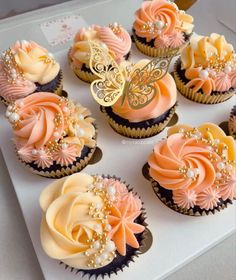 cupcakes decorated with pink, yellow and white frosting are on a tray