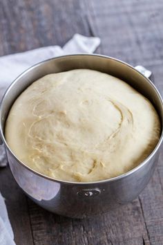 a metal pan filled with dough on top of a wooden table