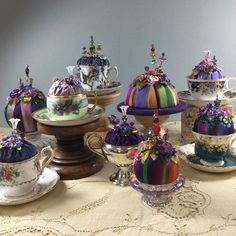 a table topped with tea cups and saucers covered in rainbow colored cake toppings