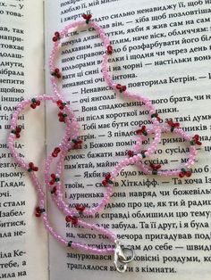 a pink beaded necklace on top of an open book