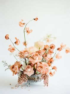 a vase filled with lots of flowers on top of a table