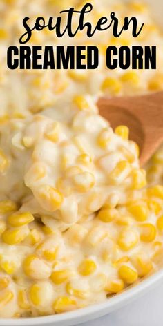 a white bowl filled with creamed corn and topped with a wooden spoon on the side