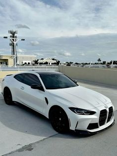 a white sports car parked on top of a parking lot