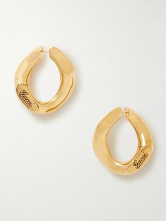 Gucci’s sculptural earrings are cast to resemble a magnified version of curb chain links. They're made from gold-tone metal and engraved with a logo in cursive lettering. Luxury Gold-tone Jewelry With Logo, Luxury Gold-tone Logo Jewelry, Luxury Gold-tone Jewelry With Logo Lettering, Formal Yellow Gold Jewelry With Gold-tone Logo Lettering, Designer Gold Jewelry With Logo, Designer Yellow Gold Jewelry With Logo Lettering, Classic Gold Jewelry With Logo, Modern Metal Jewelry With Logo, Classic Yellow Gold Jewelry With Logo