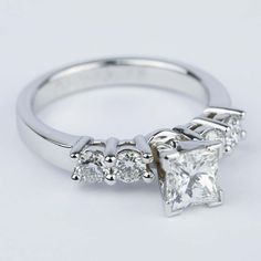 an engagement ring with three princess cut diamonds