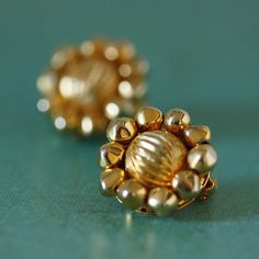 "This is a lovely pair of vintage costume jewelry earrings. There is a large gold center bead with a wavy texture surrounded by a ring of 10 smaller rounded multifaceted beads. The earrings are mounted on gold metal clip on backs which open and close easily. They are marked \"JAPAN\" on the clips. Each earring measures 0.8\" (2 cm) in diameter and 0.75\" (1.9 cm) thick. These lovely earrings are in great vintage condition and would make a wonderful addition to any wardrobe or collection. GJ050 D Costume Jewelry Earrings, Cluster Earrings, Lovely Earrings, Earrings Vintage, Vintage Costume Jewelry, Vintage Costumes, Gold Beads, Vintage Earrings, Clip On