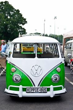 a green and white bus parked in a parking lot