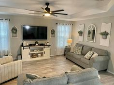 a living room filled with furniture and a flat screen tv mounted on the wall above a fireplace