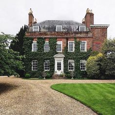 a large brick building with ivy growing on it's sides and lots of windows